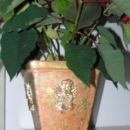Stari cvetlični lonec okrašen z odlitki angelčkov in zlatimi lističi.